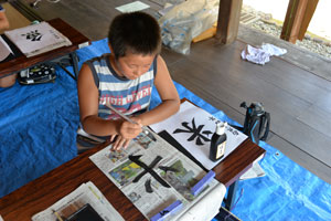 米を書く練習する男子児童